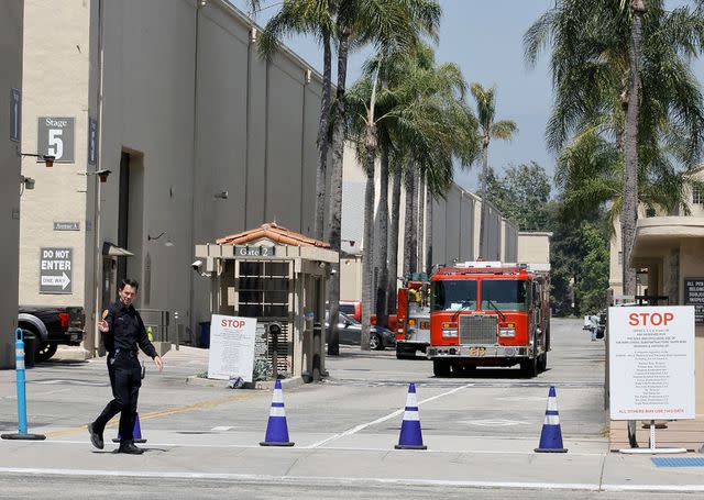 <p>Kevin Winter/Getty</p> Firefighting equipment is seen after a fire is extinguished at Warner Bros. Studios