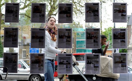 A woman stops to look in the window of an estate agent in Islington, north London, Britain, April 29, 2010. REUTERS/Paul Hackett/File Photo