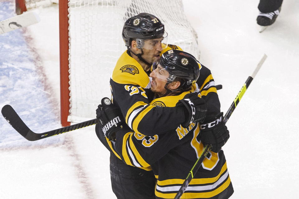 Boston Bruins' Brad Marchand (63) celebrates his goal against the Carolina Hurricanes with teammate Patrice Bergeron (37) during the second period of an NHL Eastern Conference Stanley Cup hockey playoff game in Toronto, Thursday, Aug. 13, 2020. (Chris Young/The Canadian Press via AP)