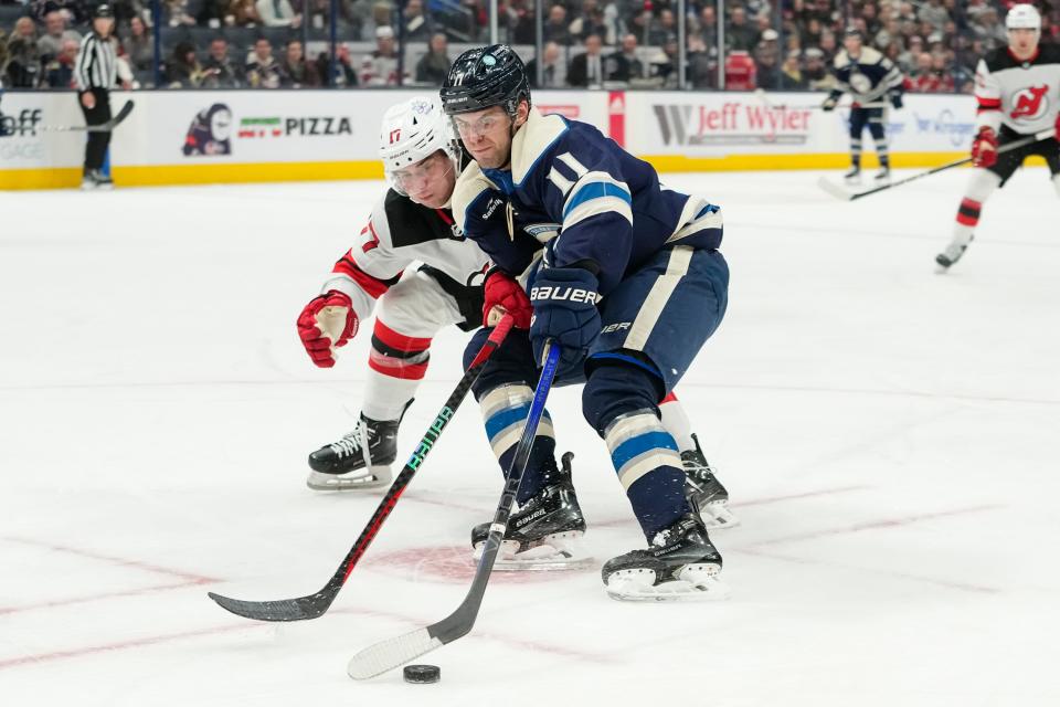 Jan 19, 2024; Columbus, Ohio, USA; Columbus Blue Jackets center Adam Fantilli (11) skates around New Jersey Devils defenseman Simon Nemec (17) during the first period of the NHL hockey game at Nationwide Arena.