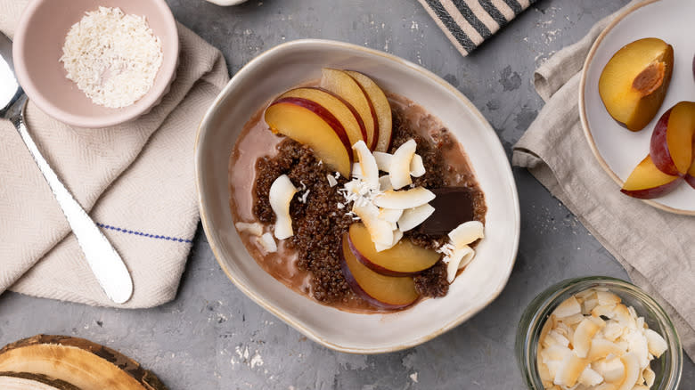 quinoa breakfast bowl with plums and coconut