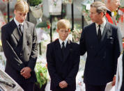 Prince Charles touches the shoulder of his son Harry as his other son Prince William watches the hearse bearing his mother Diana, Princess of Wales being driven from Westminster Abbey following her funeral service September 6. Millions of mourners lined the route to pay their respects. (Reuters)