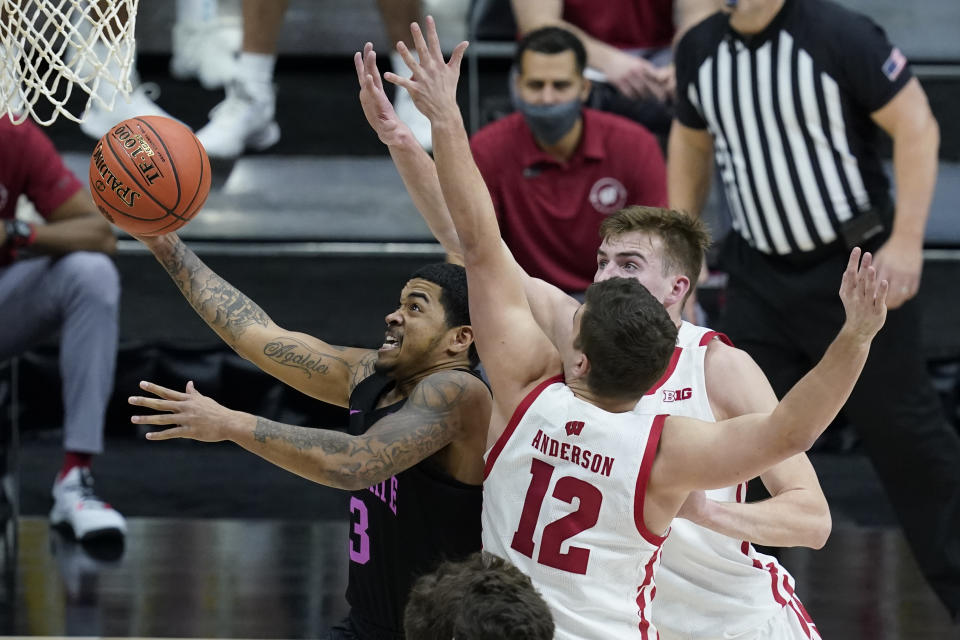 Penn State's Sam Sessoms (3) goes to the basket against Wisconsin's Trevor Anderson (12) and Tyler Wahl (5) during the first half of an NCAA college basketball game at the Big Ten Conference tournament, Thursday, March 11, 2021, in Indianapolis. (AP Photo/Darron Cummings)