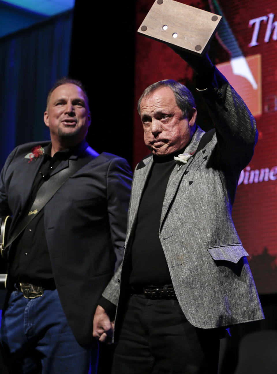 Kim Williams acknowledges the audience as he is inducted into the Nashville Songwriters Hall of Fame on Sunday, Oct. 7, 2012, in Nashville, Tenn. Garth Brooks watches at left. (AP Photo/Mark Humphrey)