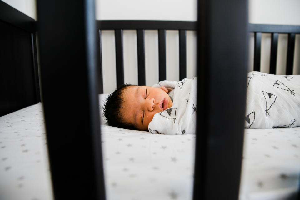 Baby swaddled sleeping in crib