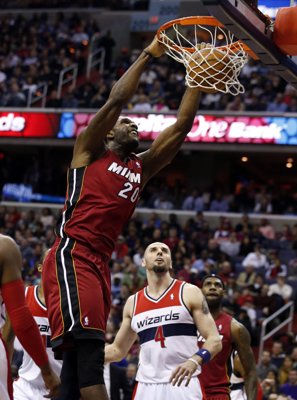 Miami Heat center Greg Oden (20) dunks the ball in front of Washington Wizards center Marcin Gortat (4), from Poland, in the first half of an NBA basketball game on Wednesday, Jan. 15, 2014, in Washington. It was Oden's first NBA regular-season game in more than four years. (AP Photo/Alex Brandon)