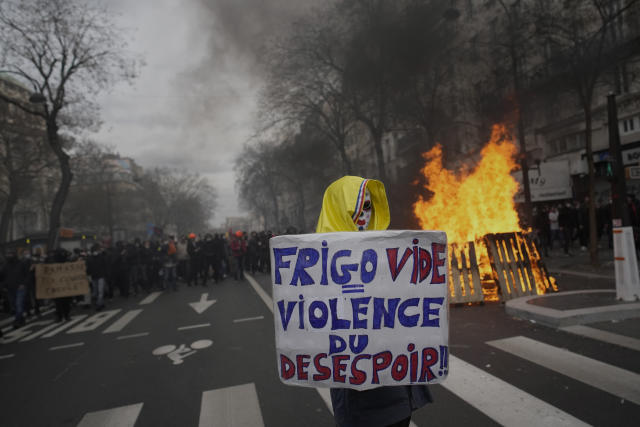 A protester holds a placard that reads, "empty fridge violence of desperation," during a rally in Paris, Thursday, march 23, 2023. French unions are holding their first mass demonstrations Thursday since President Emmanuel Macron enflamed public anger by forcing a higher retirement age through parliament without a vote. (AP Photo/Christophe Ena)