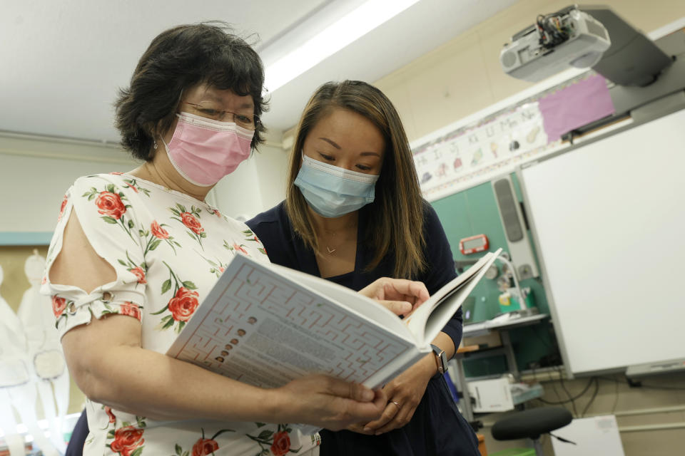 NEW YORK, NEW YORK - JULY 22:  (L-R) Principal Alice Hom and teacher Laura Lai look over the recently arrived Class of 2021 yearbook at Yung Wing School P.S. 124 on July 22, 2021 in New York City. Positive COVID-19 cases in some New York City public schools have resulted in classroom quarantines.  (Photo by Michael Loccisano/Getty Images)