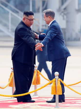 South Korean President Moon Jae-in and North Korean leader Kim Jong Un attend an official welcome ceremony at Pyongyang Sunan International Airport, in Pyongyang, North Korea, September 18, 2018. Pyeongyang Press Corps/Pool via REUTERS