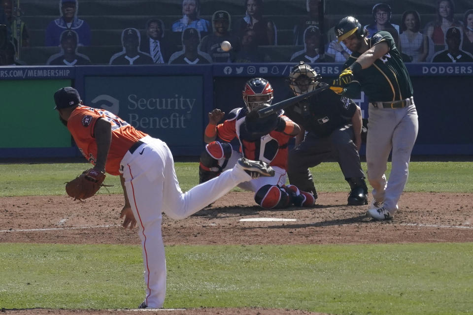 Oakland Athletics' Chad Pinder, right, hits a three-run home run off of Houston Astros pitcher Josh James, left, during the seventh inning of Game 3 of a baseball American League Division Series in Los Angeles, Wednesday, Oct. 7, 2020. (AP Photo/Marcio Jose Sanchez)