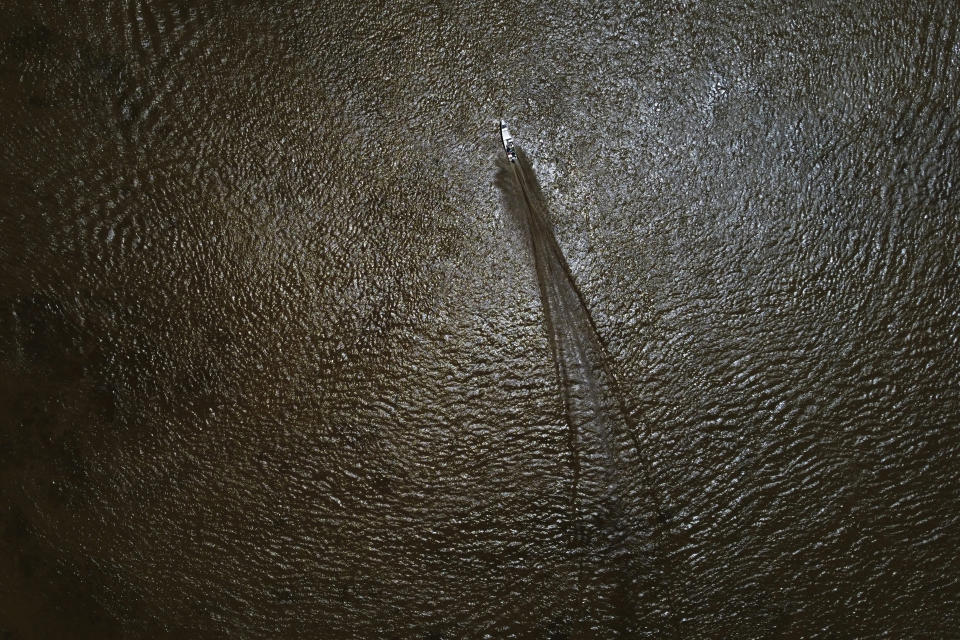 A small fisherman's boat crosses the Rio Marinheiro in front of the Vila Progresso community, in the Bailique archipelago, district of Macapa, state of Amapa, northern Brazil, Sept. 10, 2022. After a historic biodiversity agreement was reached, countries now face pressure to deliver on the promises. The most significant part of the global biodiversity framework is a commitment to protect 30% of land and water considered important for biodiversity by 2030. (AP Photo/Eraldo Peres)