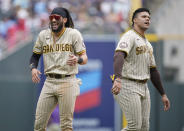 San Diego Padres right fielder Fernando Tatis Jr., left, jokes with left fielder Juan Soto as they wait for their fielding apparel to return to their positions after the top of the sixth inning of a baseball game against the Colorado Rockies, Saturday, June 10, 2023, in Denver. (AP Photo/David Zalubowski)