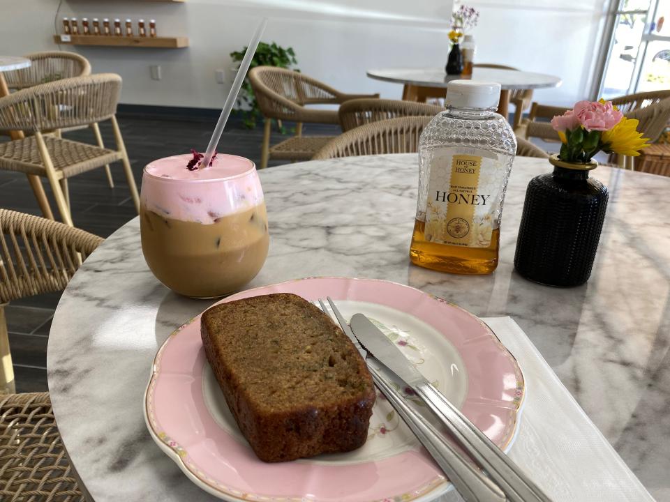 The Queen Bee latte and a gluten-free zucchini loaf on a table at House of Honey in Peoria on April 25, 2024.
