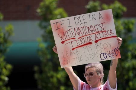 Amanda Luke, of Fairborn, Ohio, holds a sign during a vigil after a mass shooting in Dayton