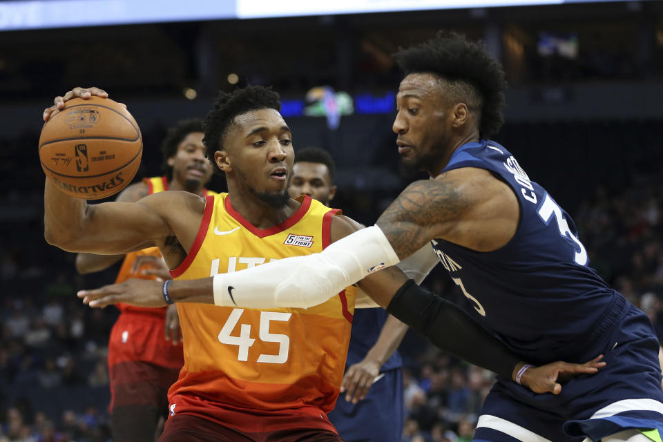 Utah Jazz's Donovan Mitchell controls the ball against Minnesota Timberwolves' Robert Covington in the first half of an NBA basketball game Wednesday, Dec. 11, 2019, in Minneapolis. (AP Photo/Stacy Bengs)