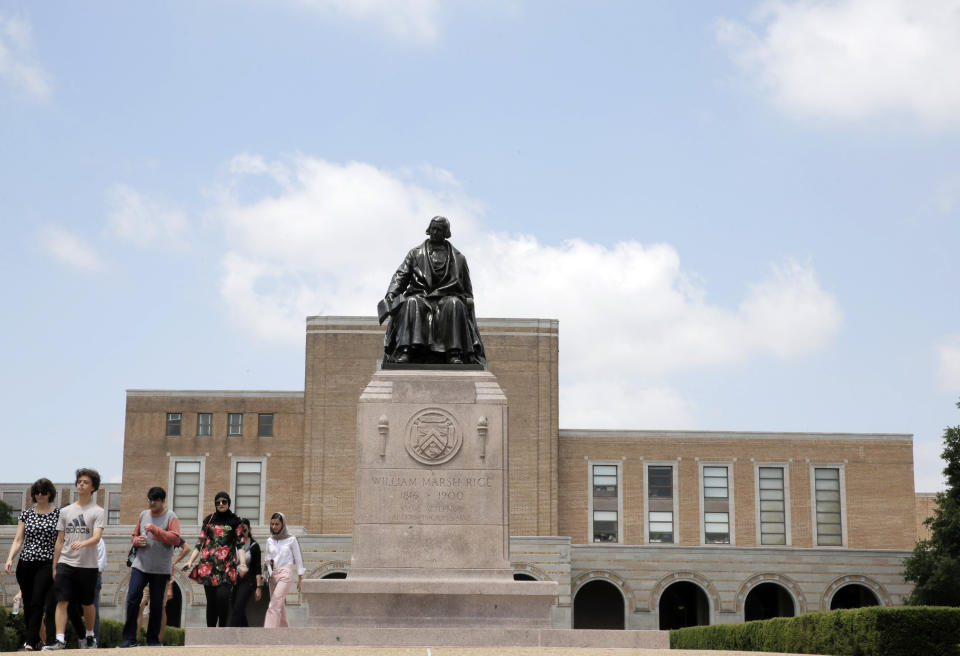 In this Friday, June 7, 2019, photo, a tour walks by the statue of Rice University founder William Marsh Rice on the campus, in Houston. Rice University started a new task force, which will explore its history and connections to slavery, segregation and racial injustice. (Elizabeth Conley/Houston Chronicle via AP)