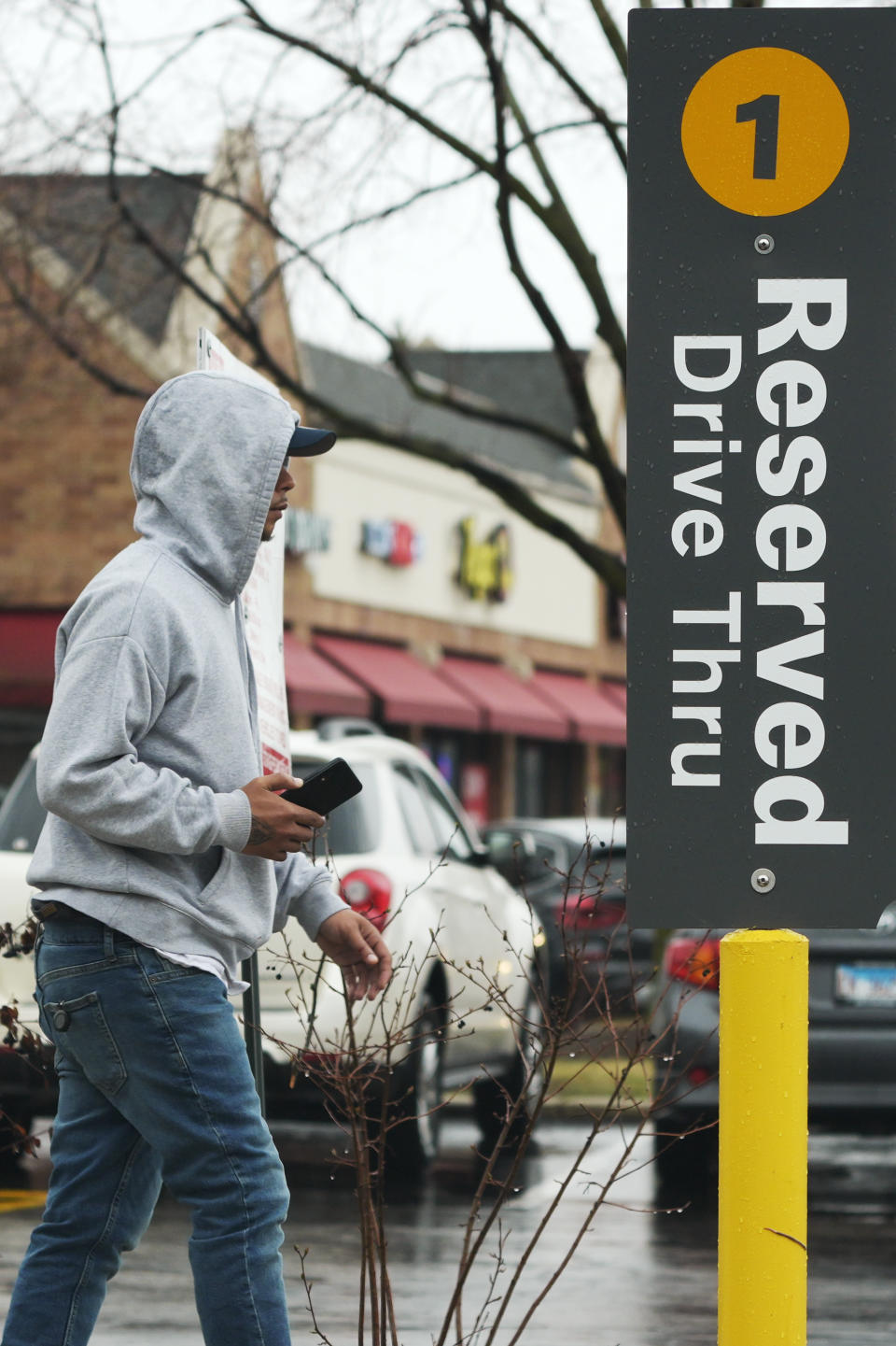 Curbside pick up sign is seen as a customer walks past at a McDonald's in Wheeling, Ill., Thursday, March 14, 2024. System failures at McDonald's were reported worldwide Friday, shuttering some restaurants for hours and leading to social media complaints from customers, in what the fast food chain called a “technology outage” that was being fixed. (AP Photo/Nam Y. Huh)