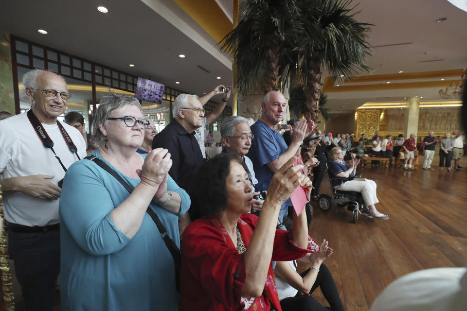 Passengers from the cruise ship Westerdam watch Cambodian dancers perform at a hotel in Phnom Penh, Cambodia, Wednesday, Feb. 19, 2020. Cambodian authority invited the passengers to entertain them. Having finally reached a friendly port willing to accept them and stepped ashore after weeks of uncertainty at sea, hundreds of the cruise ship passengers eyed warily over fears of a new virus are now simply trying to find a way home. (AP Photo/Heng Sinith)