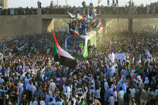 Sudanese protesters cheer as a train bearing them from the capital Khartoum arrives in the town of Atbara, the cradle of the uprising that overthrew Omar al-Bashir