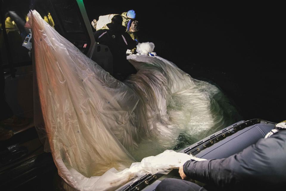 This image provided by the U.S. Navy shows sailors assigned to Explosive Ordnance Disposal Group 2 recovering a high-altitude surveillance balloon off the coast of Myrtle Beach, S.C., Feb. 5, 2023. (U.S. Navy via AP)