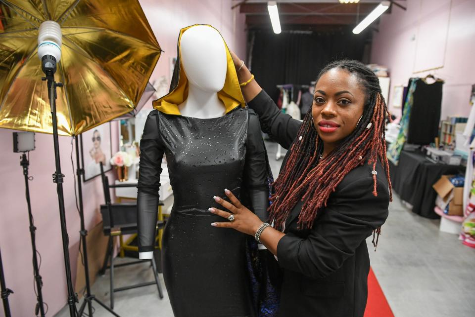 Kallee Jackson stands with one of her creations inside her business in Port St. Lucie. Jackson said some of her dress creations have been featured in Elle and Glamour magazines.