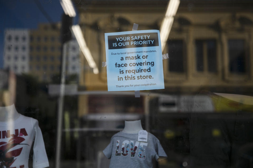 A sign requiring face masks is posted on the window of a clothing store during the coronavirus pandemic in the Westlake neighborhood of Los Angeles, Thursday, May 21, 2020. While most of California took another step forward to partly reopen in time for Memorial Day weekend, Los Angeles County didn't join the party because the number of coronavirus cases has grown at a pace that leaves it unable to meet even the new, relaxed state standards for allowing additional businesses and recreational activities. (AP Photo/Jae C. Hong)