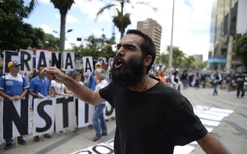 An anti-government activist shouts slogans during a protest on Friday  - Credit: AFP