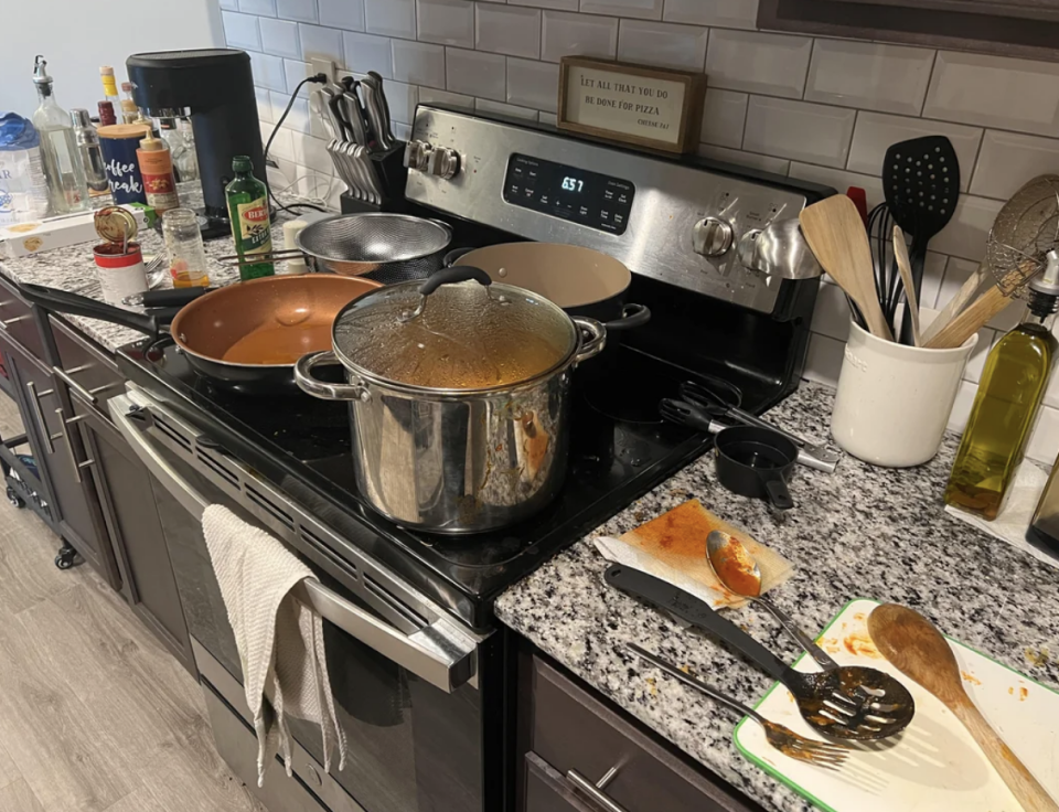 Kitchen counter with pots, pans, and cooking utensils; a meal in preparation
