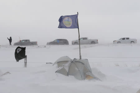 People line up in their cars as they leave Oceti Sakowin camp as "water protectors" continue to demonstrate against plans to pass the Dakota Access pipeline near the Standing Rock Indian Reservation, near Cannon Ball, North Dakota, U.S. December 6, 2016. REUTERS/Stephanie Keith