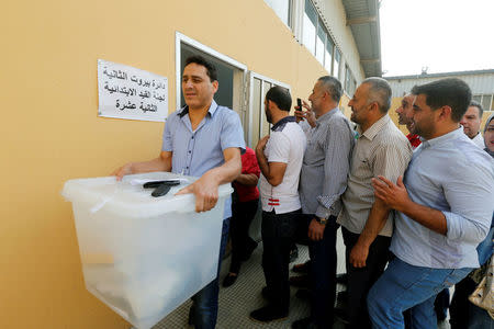 A government election official carries a ballot box which will be located in polling stations ahead of the country's May 6 parliamentary election, in Beirut, Lebanon, May 5, 2018. REUTERS/Mohamed Azakir