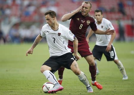 Austria's Marko Arnautovic (L) and Russia's Denis Glushakov fight for the ball during their Euro 2016 Group G qualifying soccer match at the Otkrytie Arena stadium in Moscow, Russia, June 14, 2015. REUTERS/Maxim Zmeyev