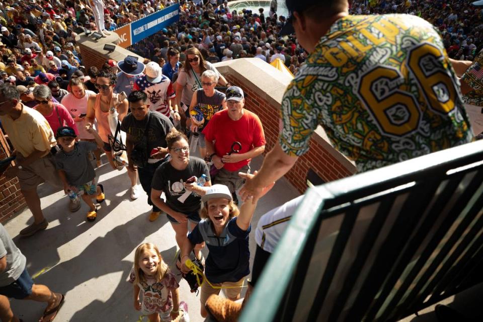 A young fan high fives a Savannah Bananas player as crowds enter the Durham Bulls Athletic Park in Durham, N.C. on Friday, July 14, 2023.