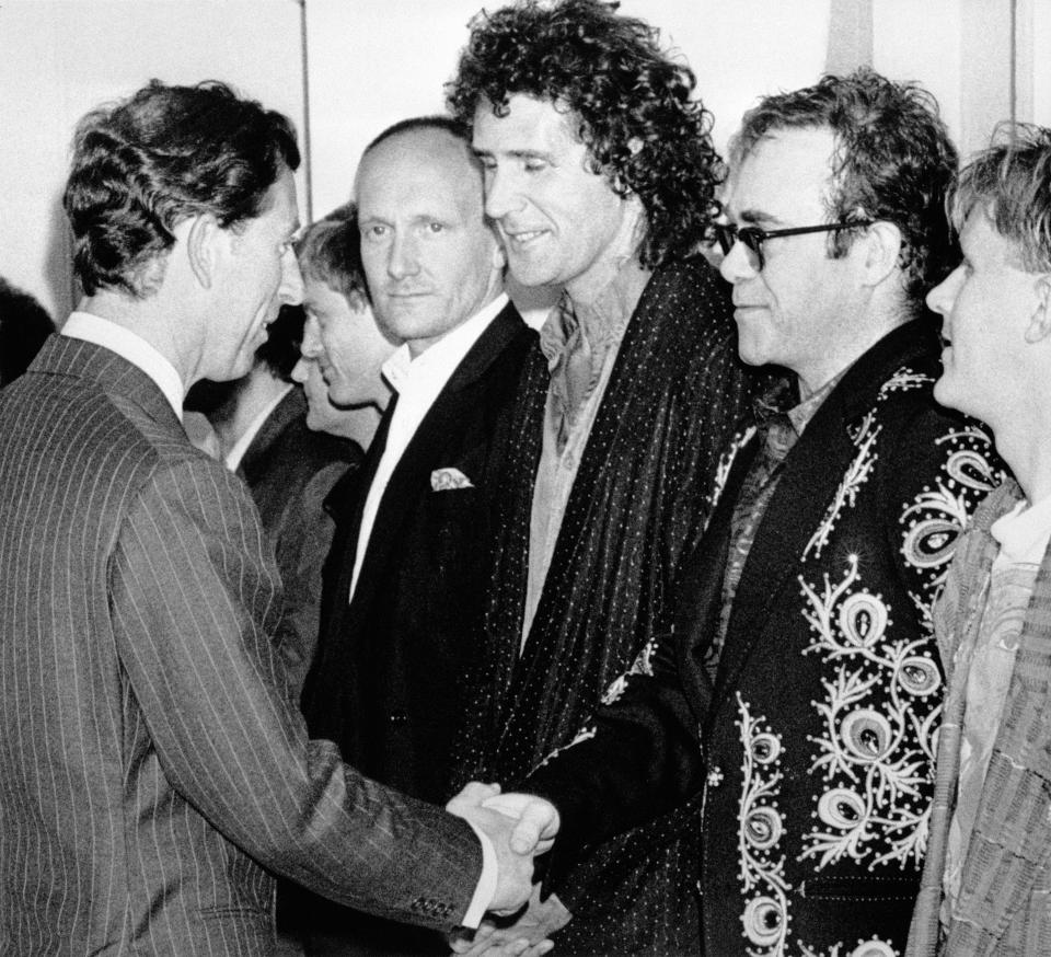 The Prince of Wales shakes hands with Elton John, flanked by his drummer Ray Cooper (l) and Dire Strait's bassist John Illsley (centre) before tonight's rock extravaganza at Wembley to celebrate 10 years of the Prince's Trust.