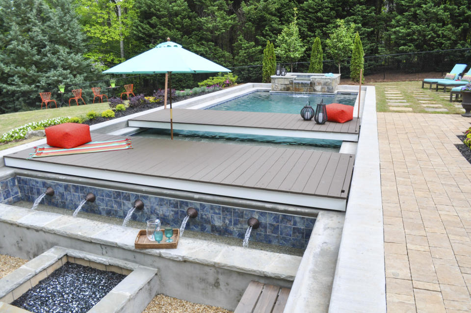 This undated photo provided by Chip Wade and Wade Works shows a pool area with movable platforms, and concealable hot tub, which make for a multi-use backyard in Johns Creek, Ga., that cleverly maximizes the square footage. (wadeworkscreative.com/Chip Wade via AP)