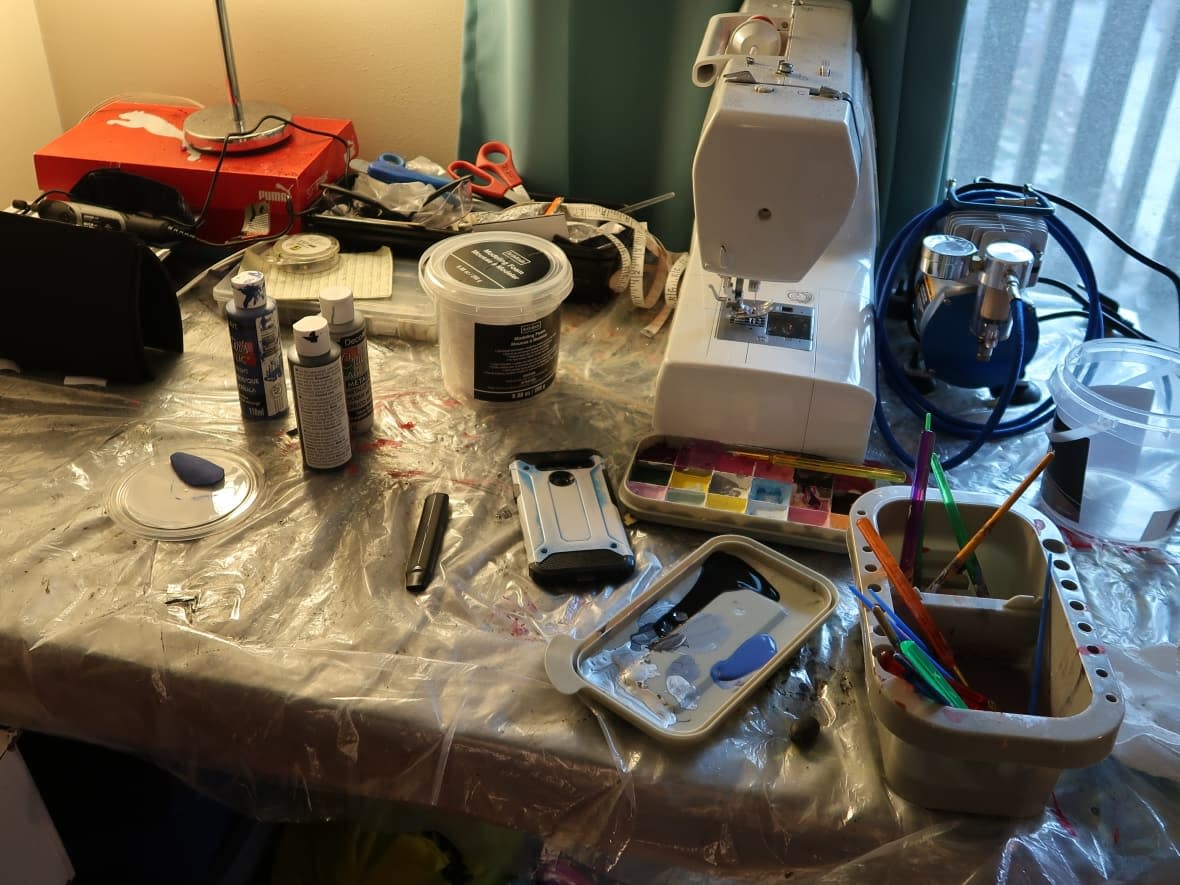 The craft table at the family's apartment is filled with paint, sewing materials and modelling foam. (Taylor Simmons/CBC - image credit)