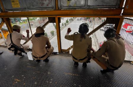 Indian policemen watch stone pelting from a footbridge during a protest in Srinagar, May 9, 2017. REUTERS/Danish Ismail