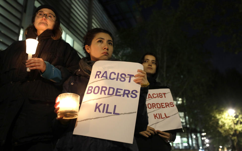 Demonstrators hold banners and candles during a vigil for the 39 lorry victims, outside the Home Office in London, Thursday, Oct. 24, 2019. Authorities found 39 people dead in a truck in an industrial park in England on Wednesday and arrested the driver on suspicion of murder in one of Britain's worst human-smuggling tragedies. (AP Photo/Kirsty Wigglesworth)