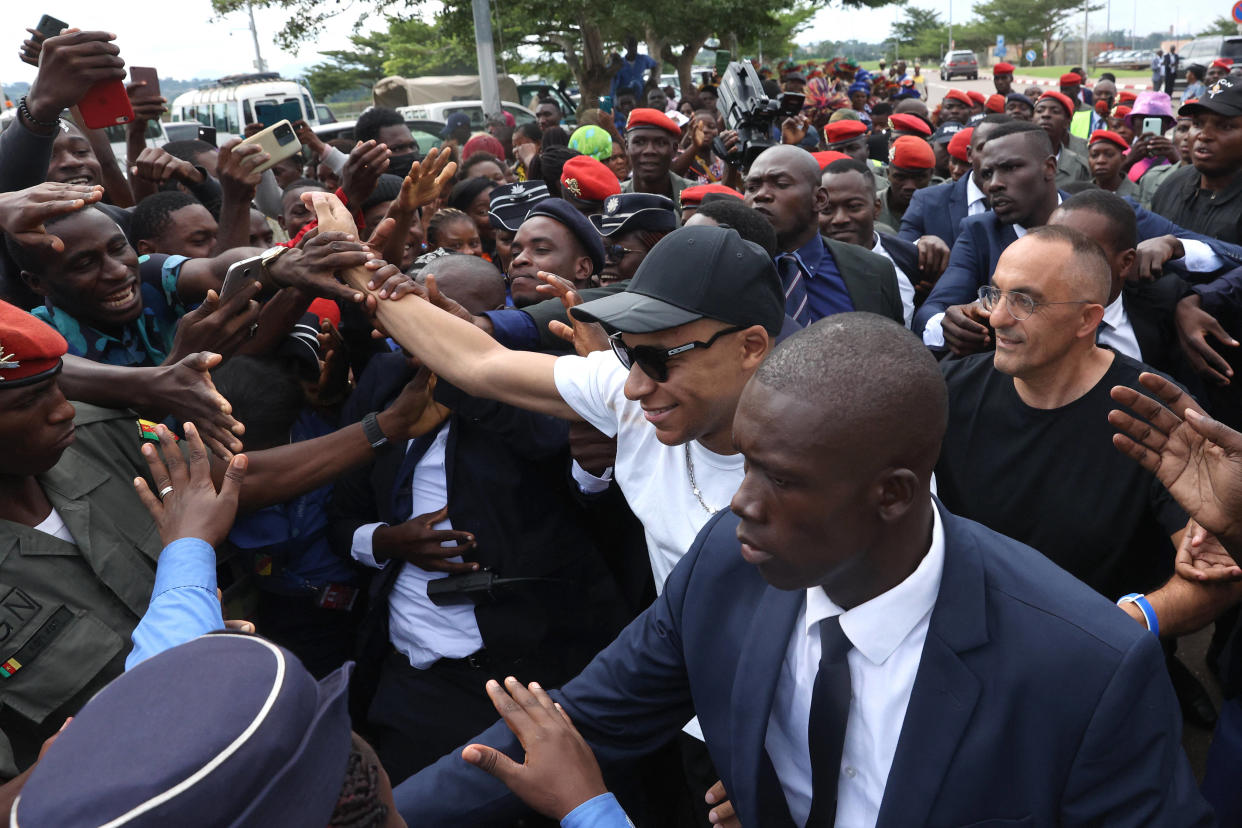 Kylian Mbappé salue la foule rassemblée à l’extérieur de l’aéroport de Yaoundé, le 6 juillet 2022. 