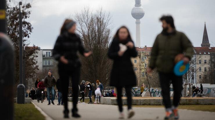 27.02.2021, Berlin: Spaziergänger gehen vor dem Berliner Fernsehturm durch den Mauerpark. Foto: Christoph Soeder/dpa +++ dpa-Bildfunk +++ Foto: dpa