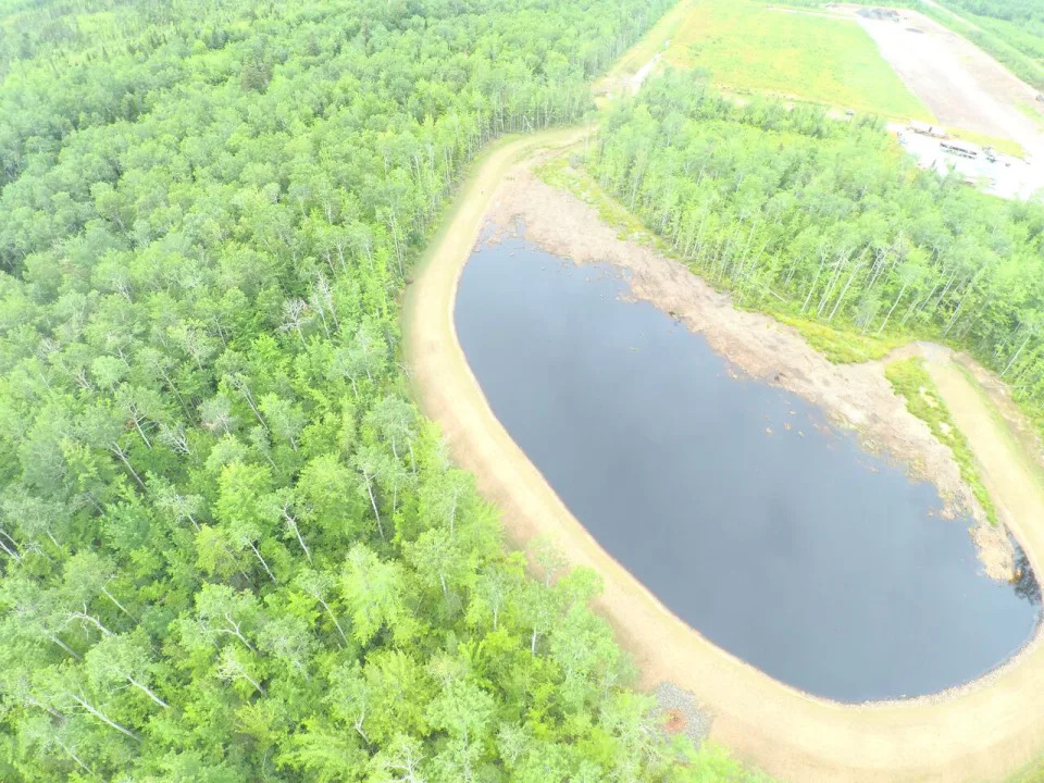 An aerial photo shows the constructed wetland when it was newly created and the snow dump pad above it.