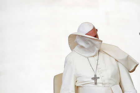 FILE PHOTO : A gust of wind blows off Pope Francis' mantle during the weekly audience in Saint Peter's Square at the Vatican, June 15, 2016. REUTERS/Tony Gentile/File Photo