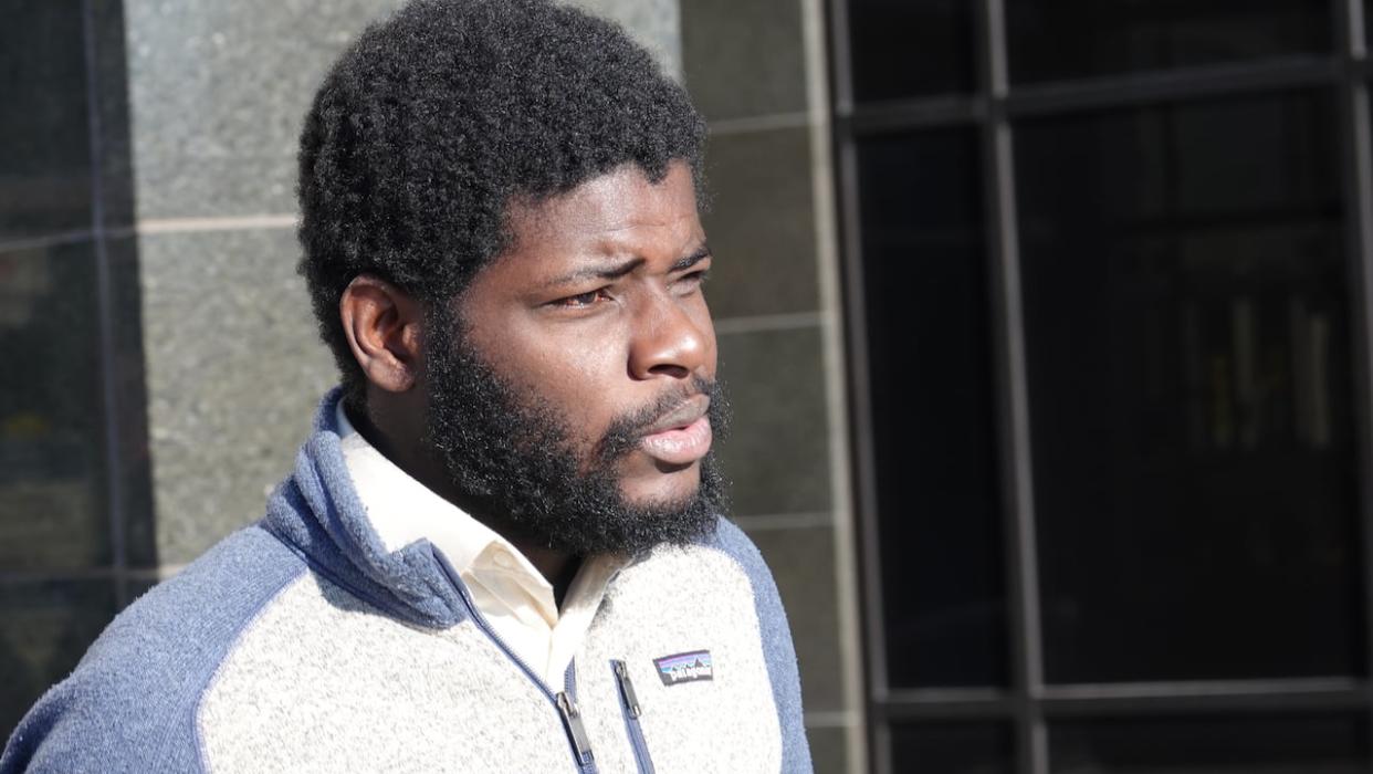 Ketiboua Kesse, 27, leaves Moncton provincial court on Tuesday. Kesse faces charges of possessing more than $5,000 obtained by crime and money laundering. (Pascal Raiche-Nogue/Radio-Canada - image credit)