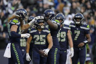 Seattle Seahawks running back Travis Homer (25) celebrates his touchdown with teammates during the second half of an NFL football game Sunday, Nov. 27, 2022, in Seattle. (AP Photo/Gregory Bull)