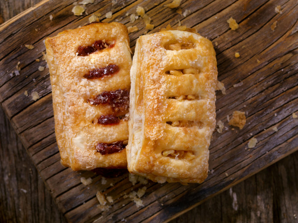 Two fruit strudels on a wooden table.