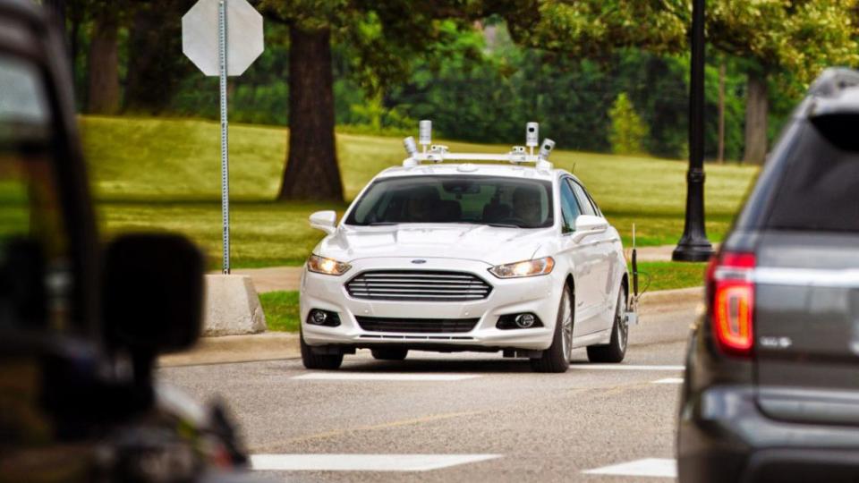 A Ford Fusion sedan outfitted with lidar cameras is seen on the road