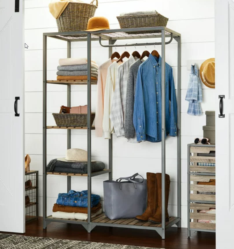 garment rack full of clothes and shoes/bags