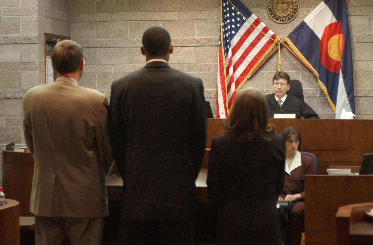 EAGLE, CO - MAY 11:  L.A. Lakers basketball player Kobe Bryant (2nd L) stands before Judge Terry Ruckriegle (R) with Hal Haddon (L) and Pamela Mackey inside Courtroom one at the Eagle County Justice Center May 11, 2003 in Eagle, Colorado. Bryant pleaded not guilty during proceedings May 11 in his sexual abuse case.  (Photo by Ed Andriesk-Pool/Getty Images)        