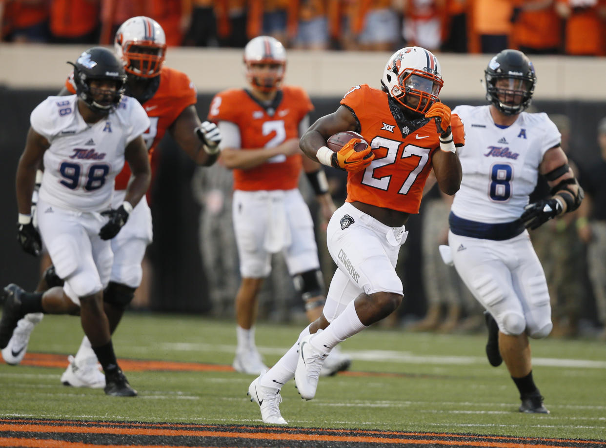 Oklahoma State running back J.D. King (27) breaks through the line and runs past Tulsa’s Jeremy Smith (98) and Jesse Brubaker (8) for a 71-yard touchdown during the first half of an NCAA college football game against Tulsa in Stillwater, Okla., Thursday, Aug. 31, 2017. (AP Photo/Sue Ogrocki)