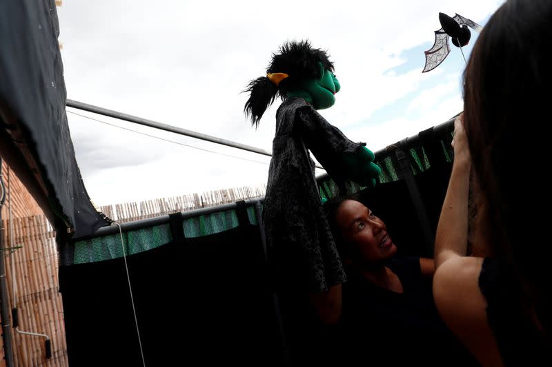 Actress and puppeteer Yohana Yara performs with her colleague Alicia Lorente as Jerome Rader films their puppet show at her home in Madrid