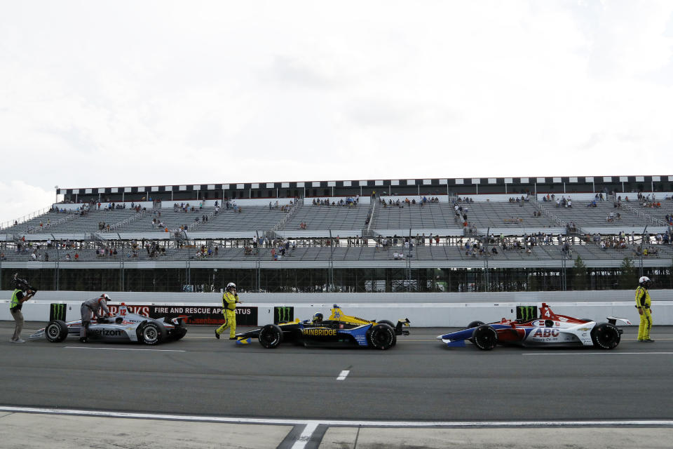 Drivers park on pit road as inclement weather delays an IndyCar Series auto race at Pocono Raceway, Sunday, Aug. 18, 2019, in Long Pond, Pa. (AP Photo/Matt Slocum)